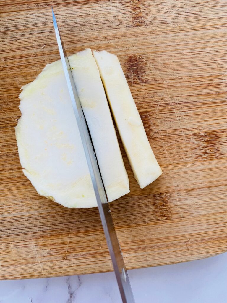 slicing raw celeriac into chips