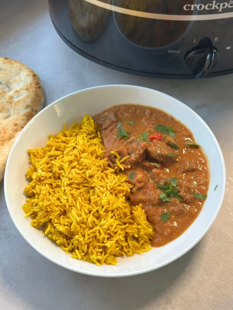 beef curry next to pilau rice next to a slow cooker