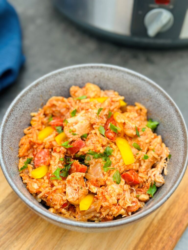 chicken and chorizo with rice in a bowl next to slow cooker