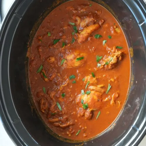 chicken tikka masala cooked in a slow cooker with fresh coriander sprinkled on top