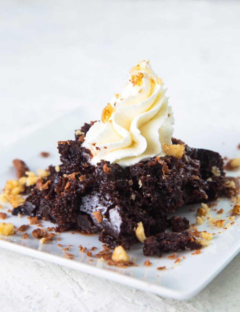 slow cooker chocolate lava cake on a plate with cream