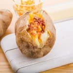 slow cooker jacket potatoes with cheese and bacon topping