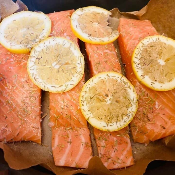 slow cooker salmon with sliced lemons and dried herbs on top