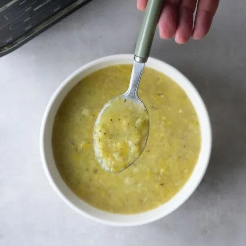 soup maker cabbage and leek soup served in a white bowl with a spoon above it in front of a ninja soup maker