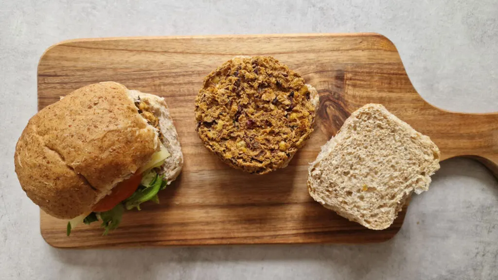 1 spicy bean burgers in baps on wooden board