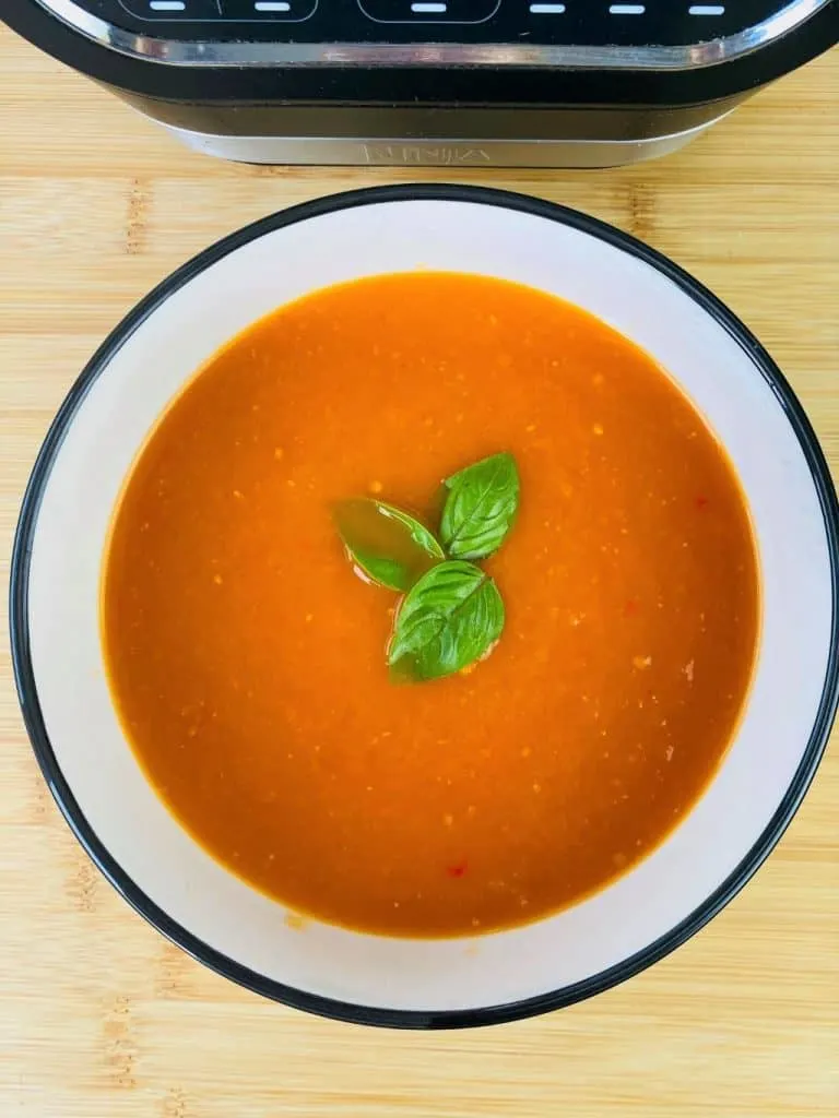 spicy tomato soup next to Ninja Soup Maker