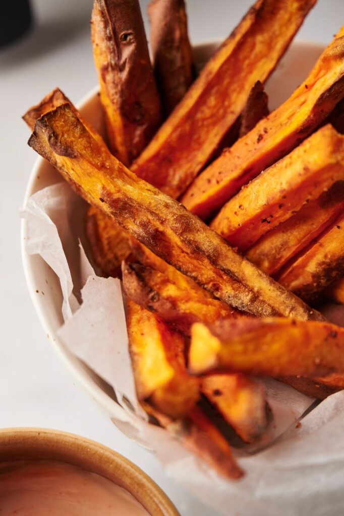 sweet potato fries next to air fryer