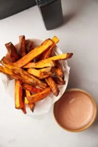 sweet potato fries snack next to a dip and air fryer