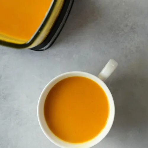 tikka butternut squash soup in a large white mug next to a Ninja soup maker