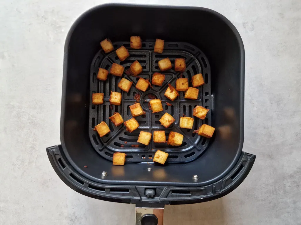 tofu chunks in an air fryer basket