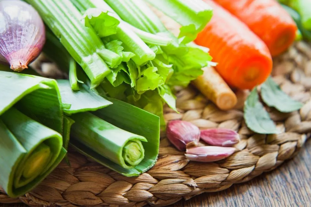 vegetable stock ingredients - onions, celery, carrots, bay leaves, garlic cloves, leeks